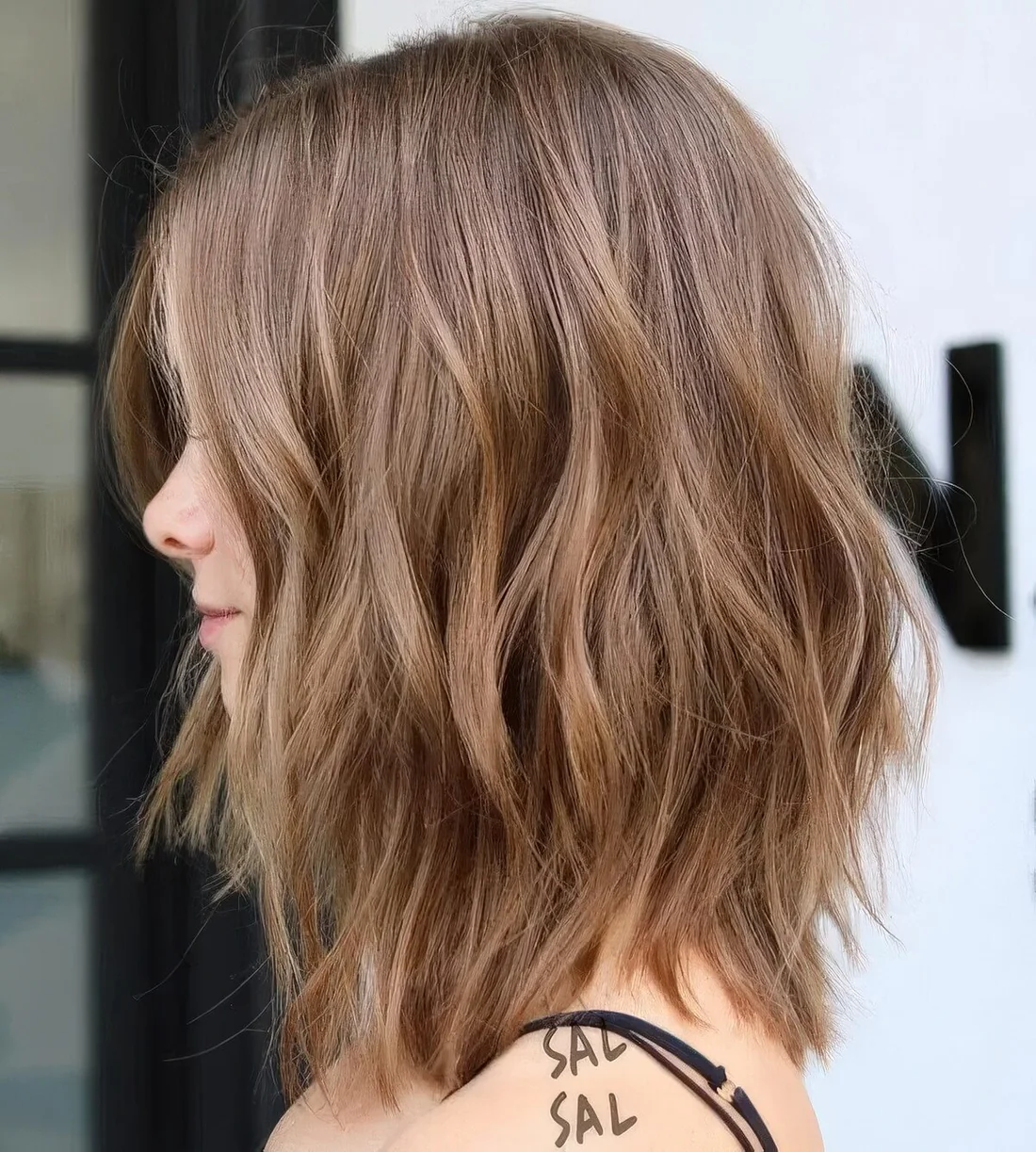 Light brunette layered long bob with some highlights for a texture, waves for a messy and voluminous look.