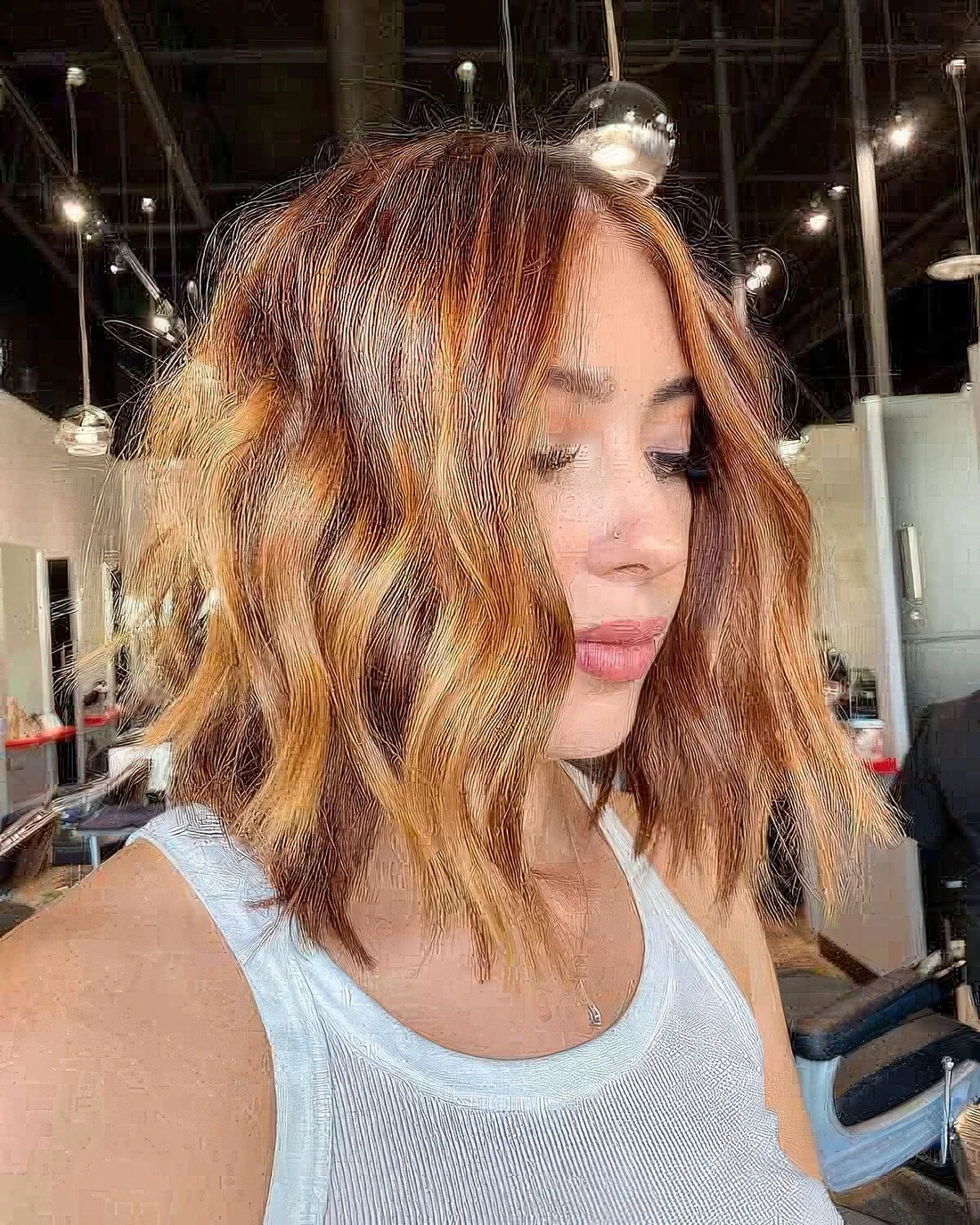 Auburn and orange wavy long bob with layers and a shiny finish.