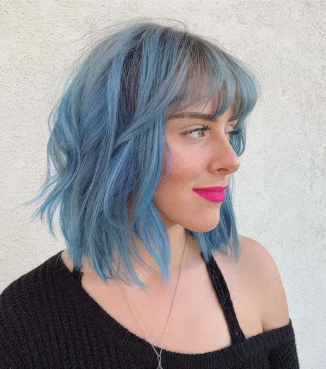 Shaggy long bob with bangs done in light blue with waves.