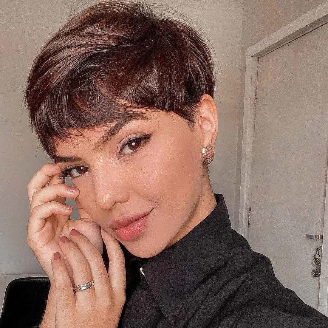 Layered pixie haircut in a rich brown shade, with soft layers.