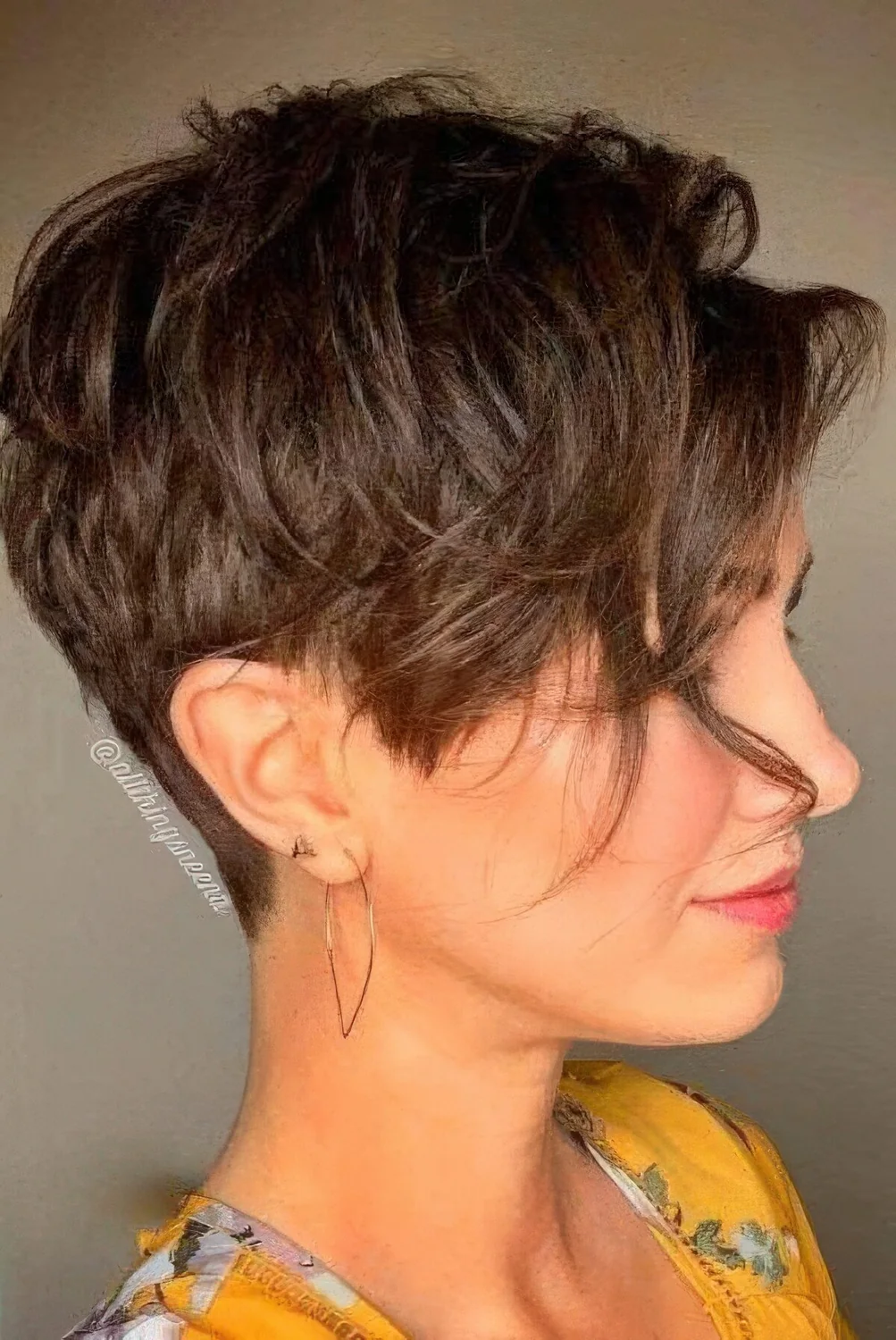 Brown layered pixie with longer side bangs and longer layers on top.