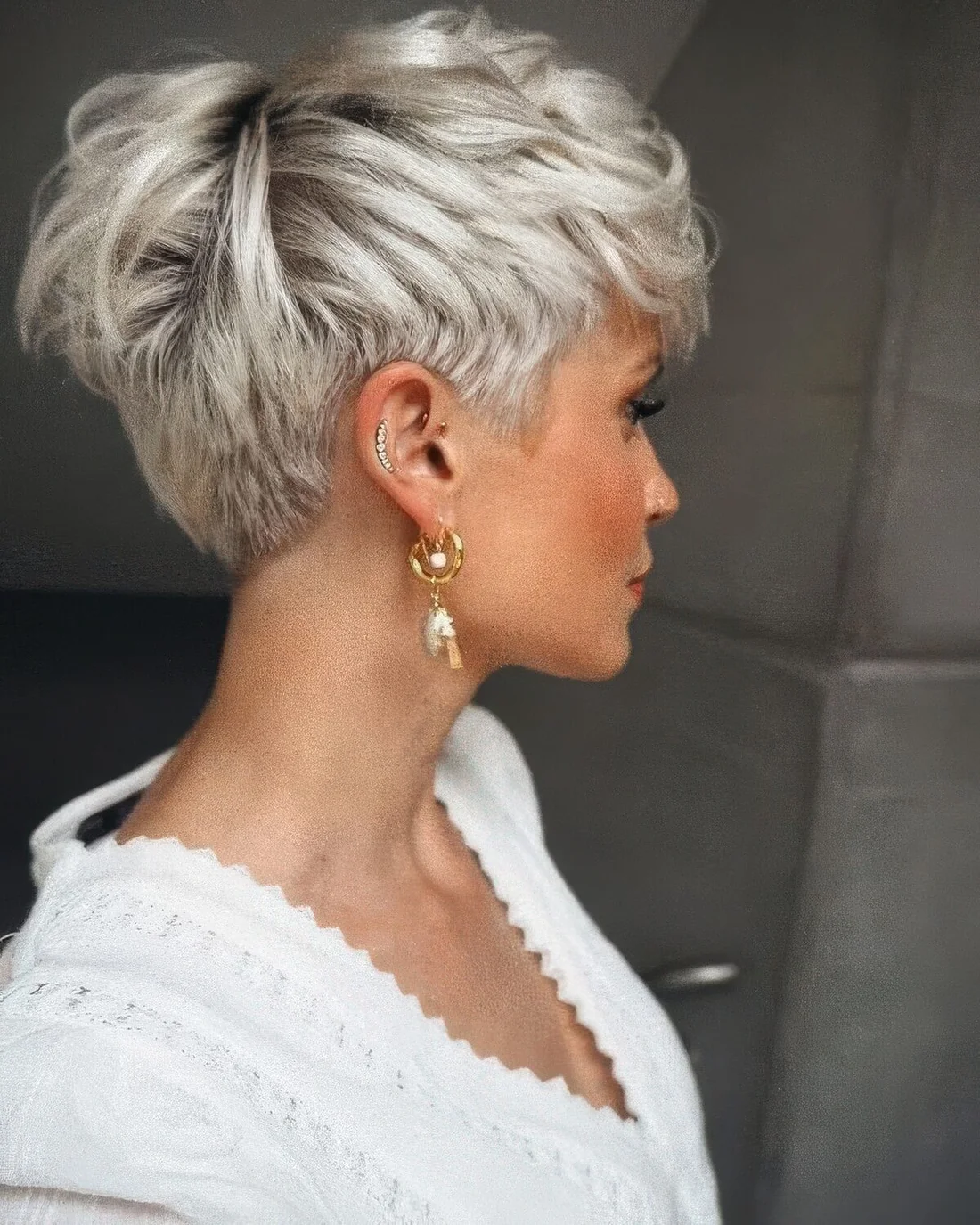 Ice blonde layered pixie cut with darker root.