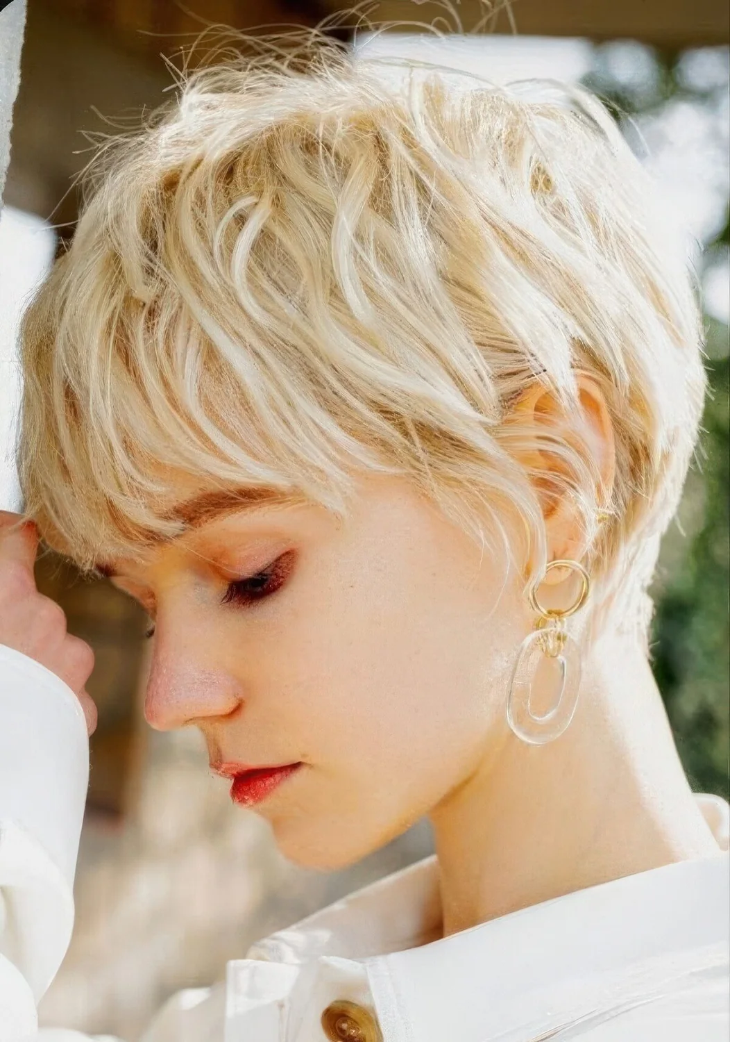 Messy creamy blonde layered pixie haircyt with feathered layers.
