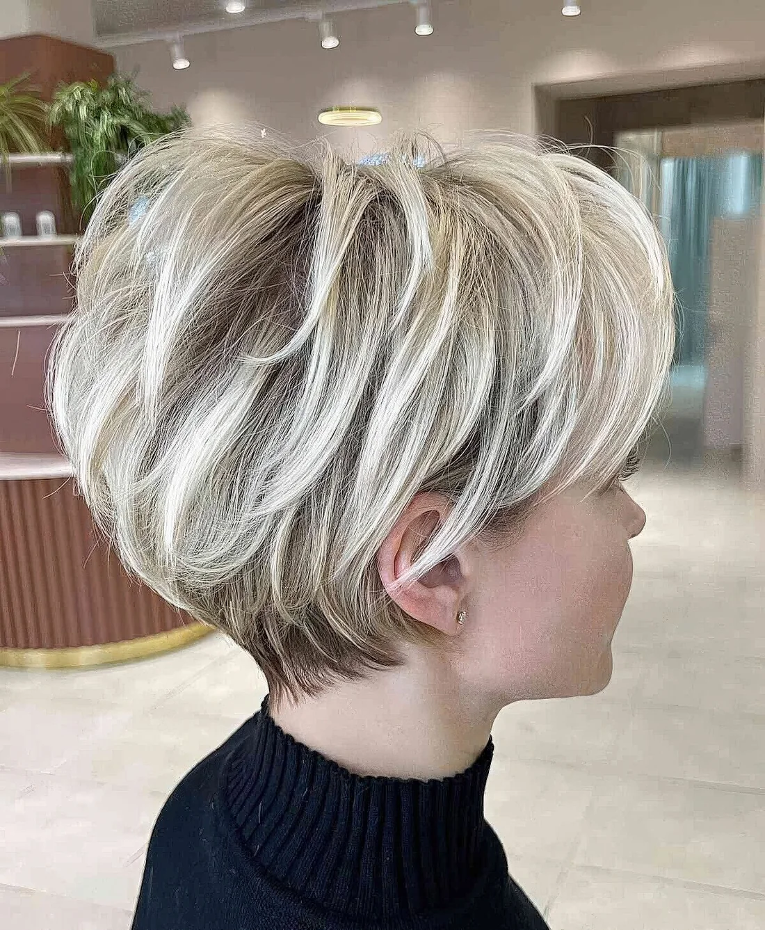 Icy blonde layered pixie bob with darker root.