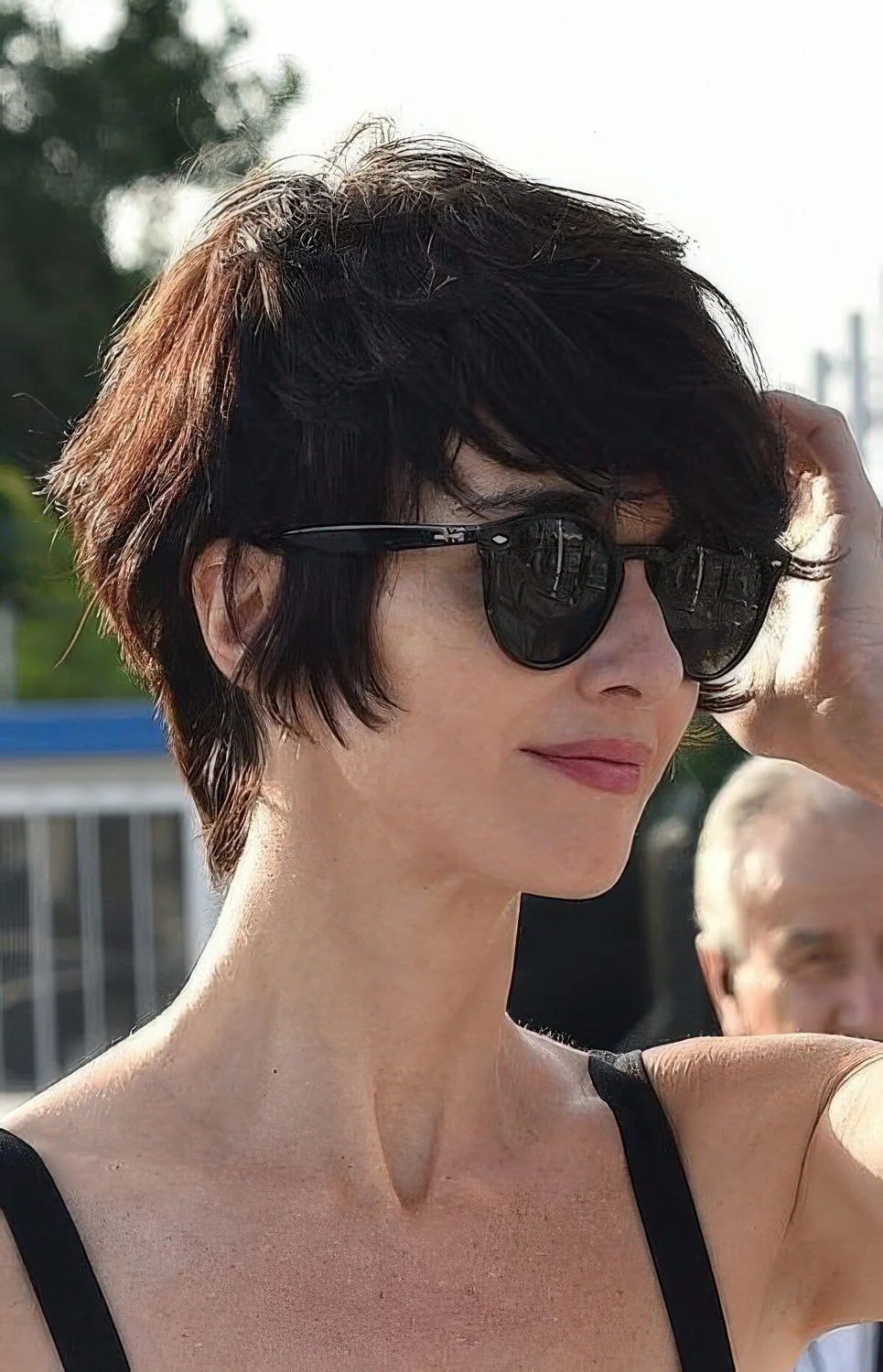 Textural and layered bixie haircut in a dark tone, with bangs.
