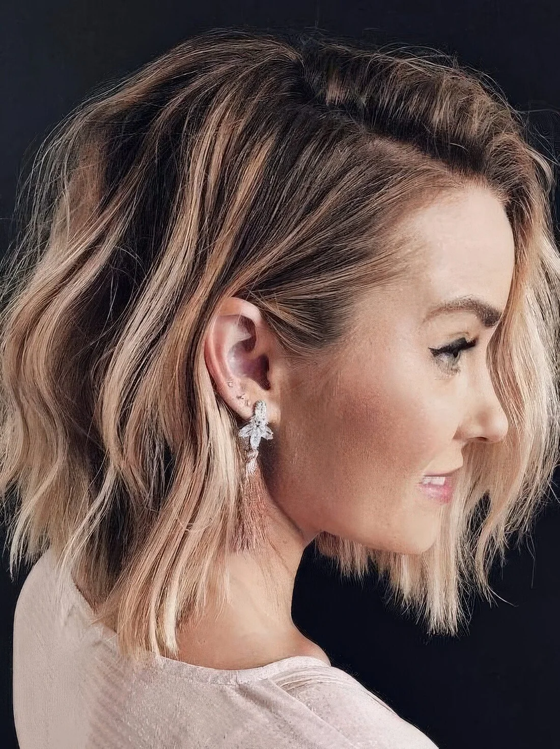 Chic light brunette long bob with blonde highlights and messy waves.