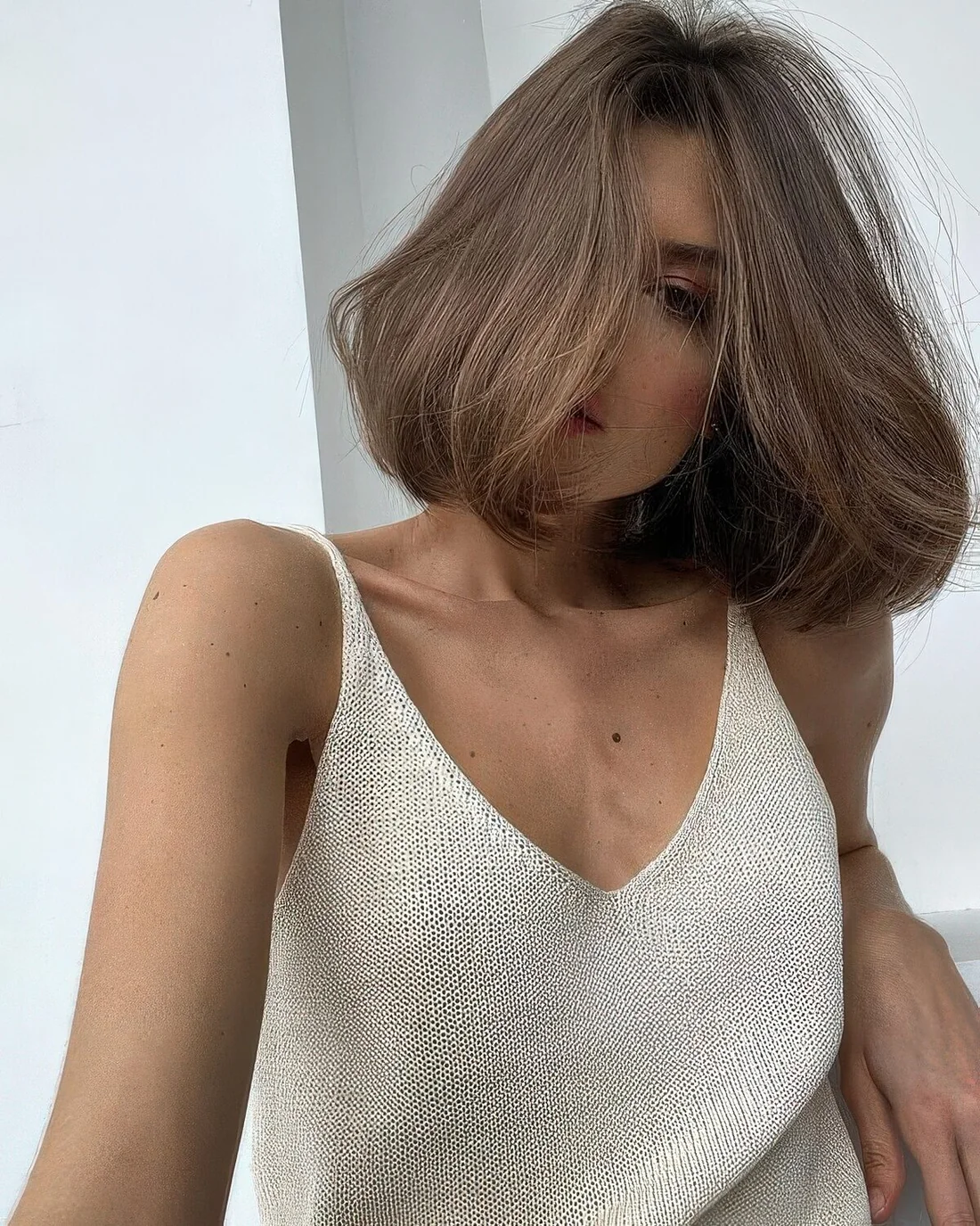 Volumetric midi light brunette bob with curved ends.