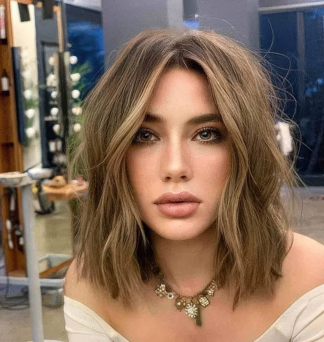 Long layered bob with blonde highlights and messy waves.