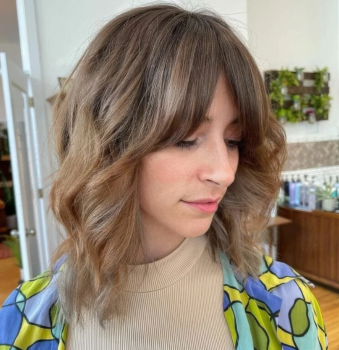 Bronde ombre long wavy bob with curtain fringe and highlights.