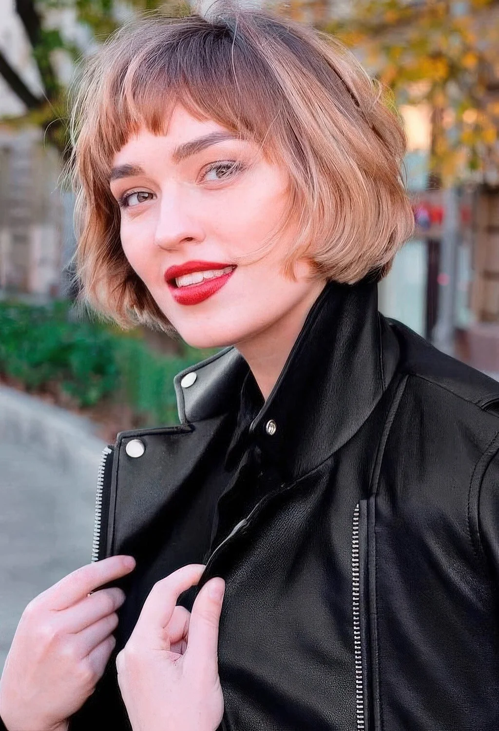 Jaw-length brunette bob with blonde balayage and waves plus bangs.