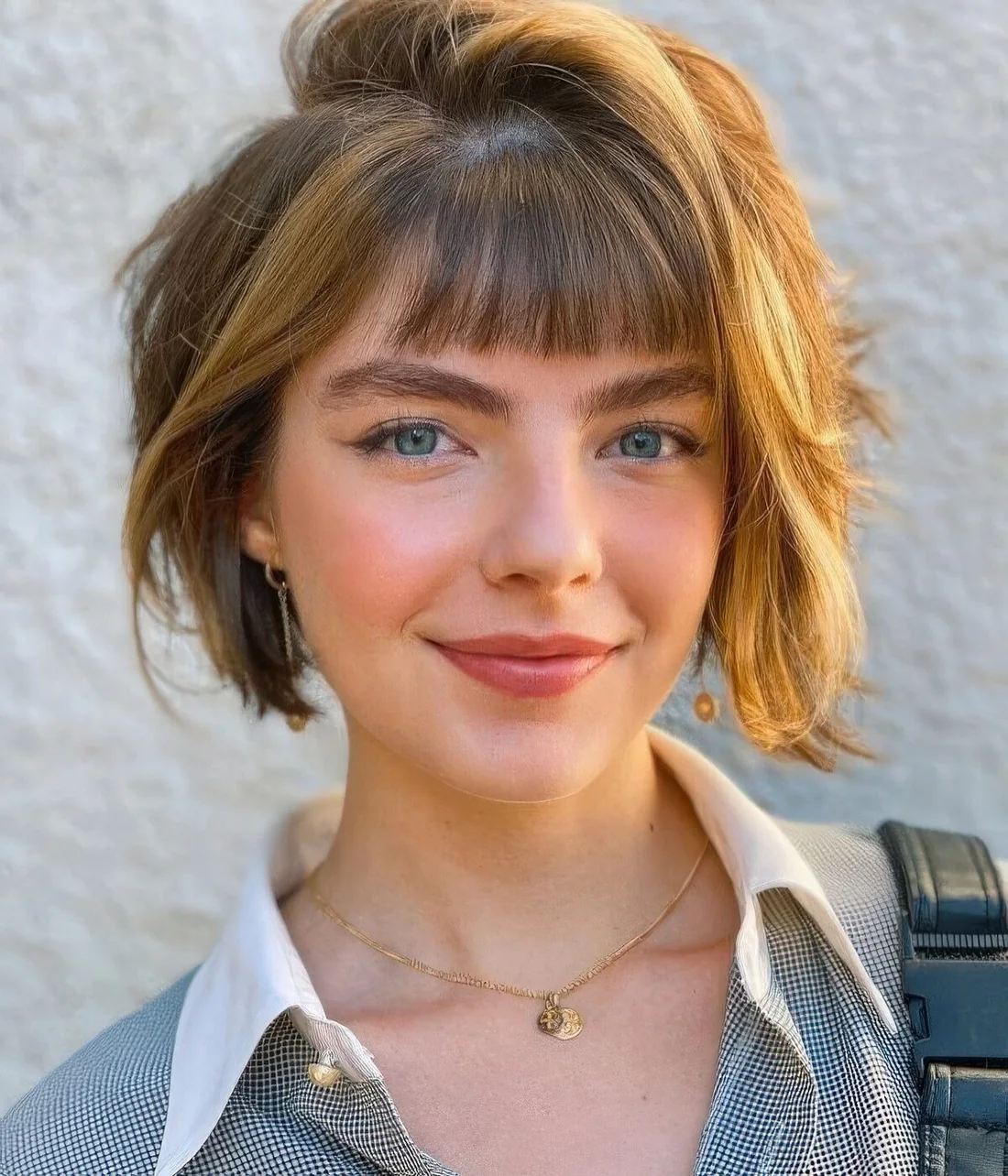 Layered bob with brighter locks and small, baby bangs.