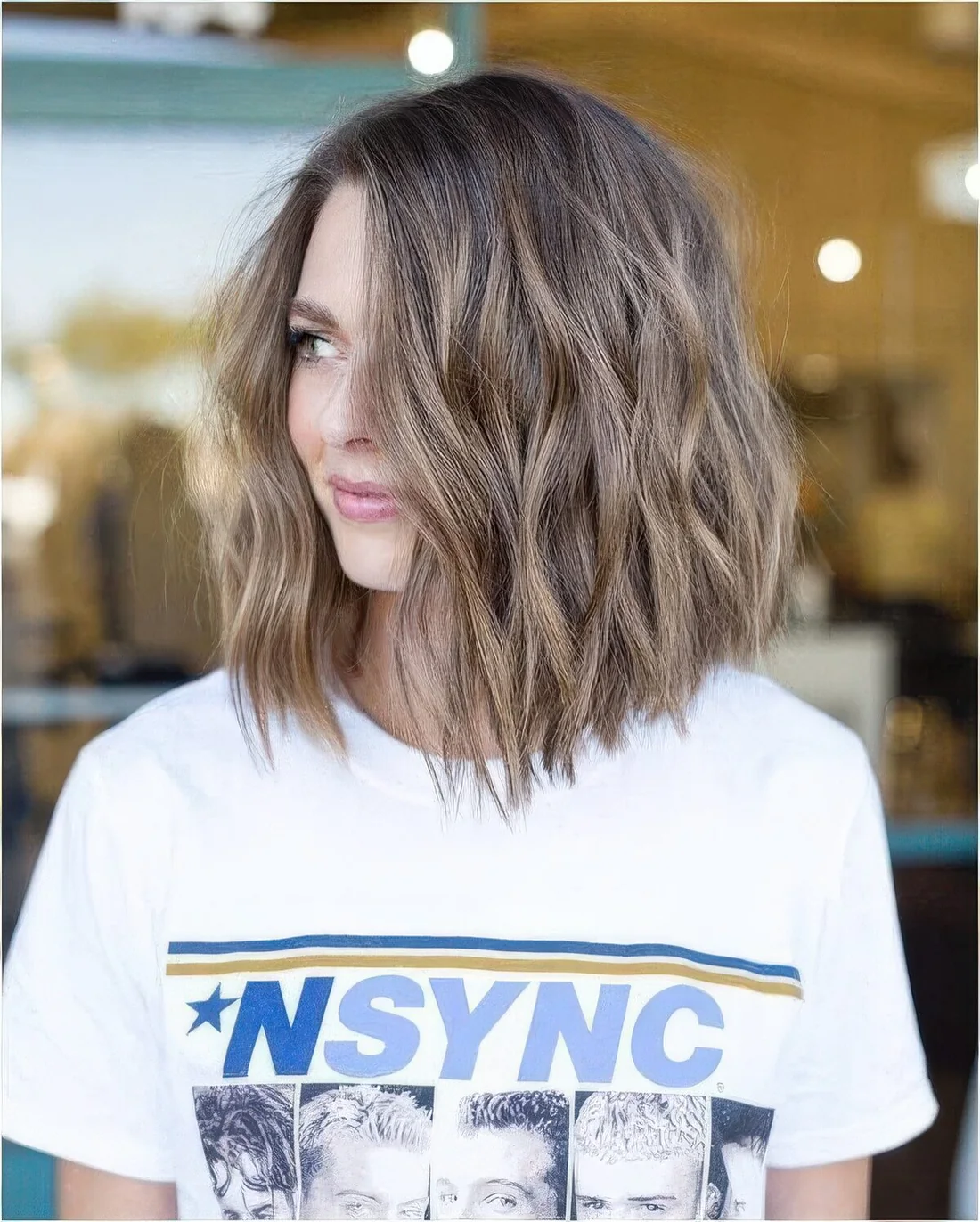 Light brown wavy long bob with some highlights.