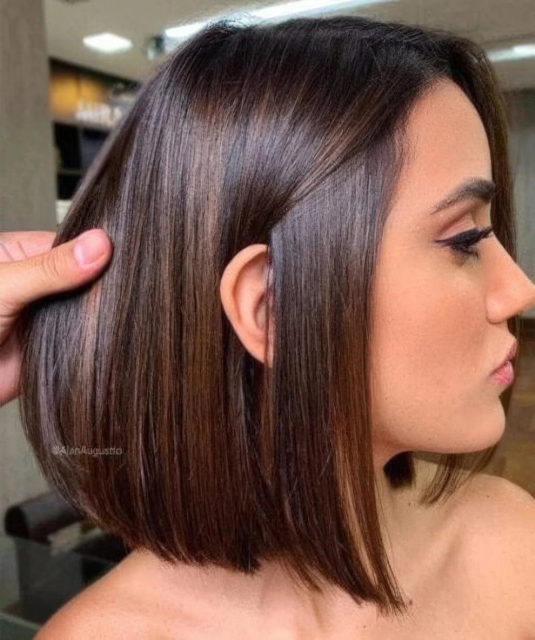 Chic deep brown liquid long bob with center part and a bit of caramel balayage.