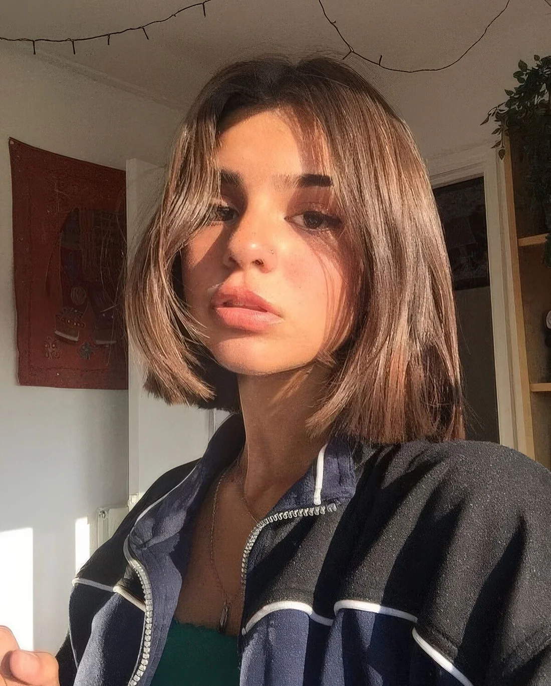 Liquid brown bob with side bangs, a voluminous root and center part.