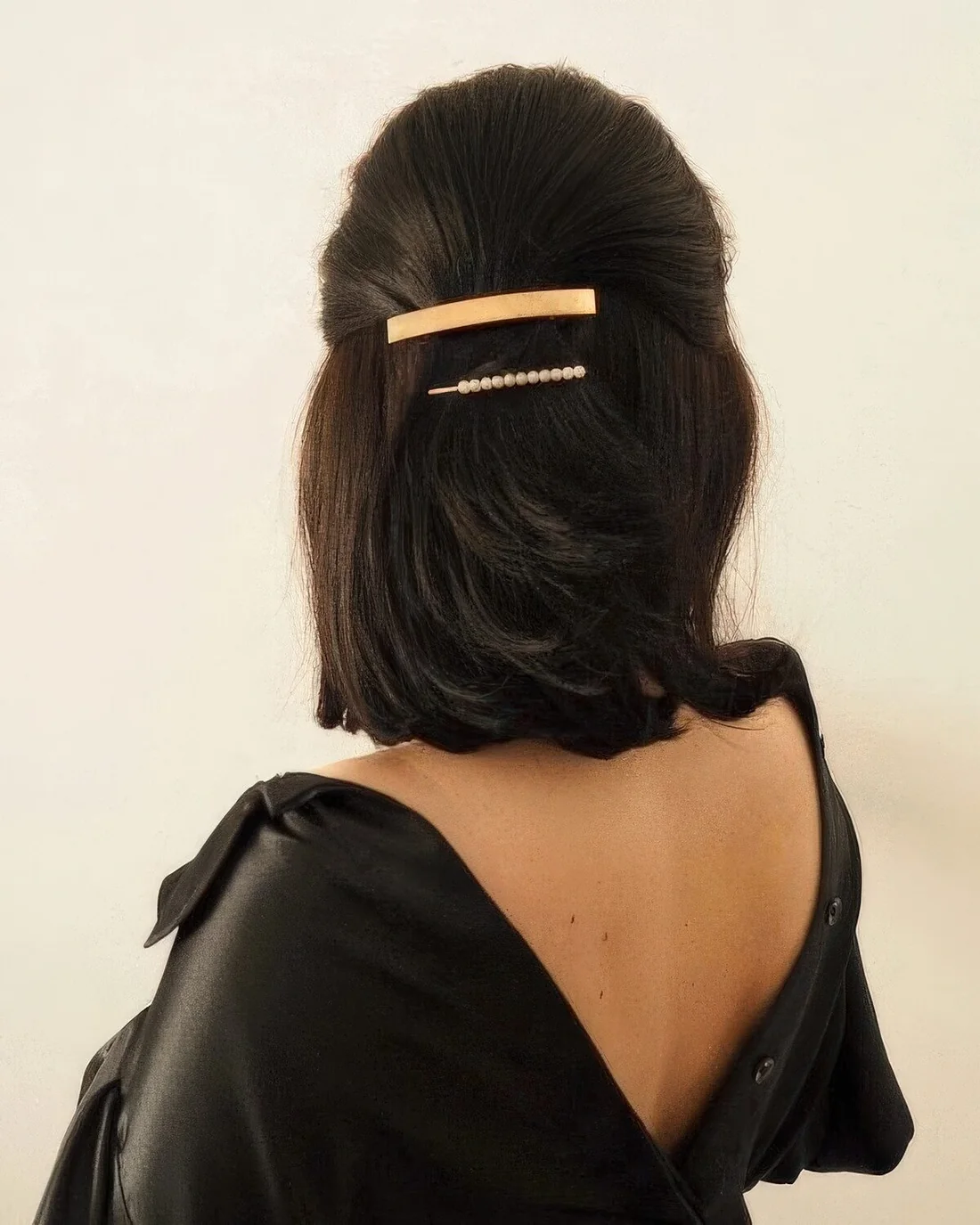 Classic half updo with a sleek top, a gold and pearl hair barrette and hair down.