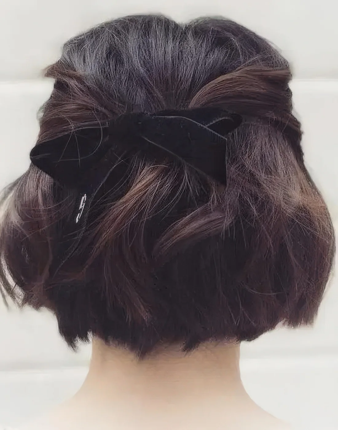 Half updo with twisted touches, a lot of volume and waves, a black velvet ribbon bow.
