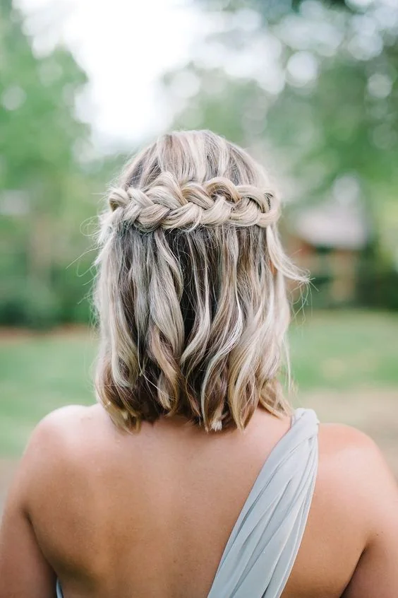 Messy half updo with a large braid and balayage.