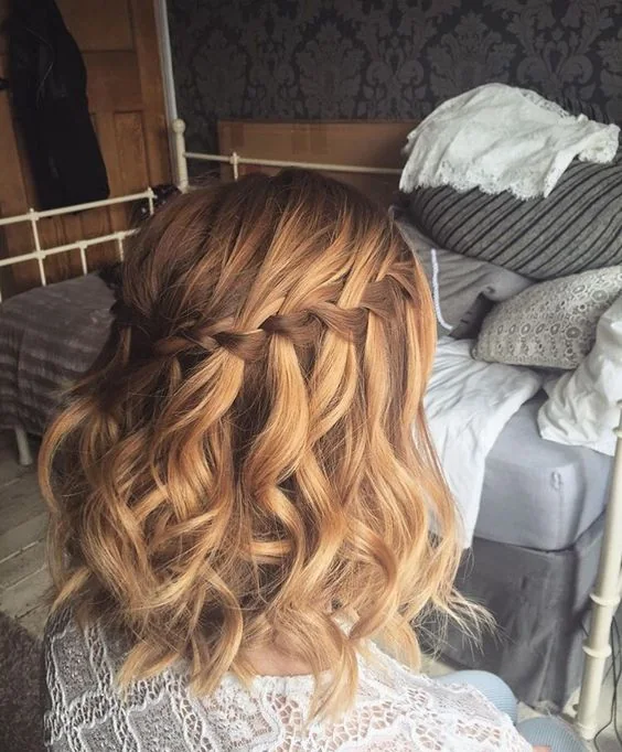 Photo showing wavy half updo with a braided top, with the hairstyle clearly visible.