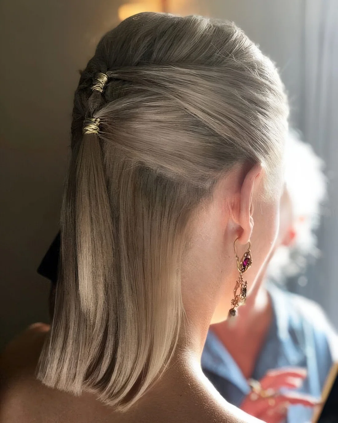 Half updo with a midi ponytail and a bump on top, straight hair down and a gold accents.