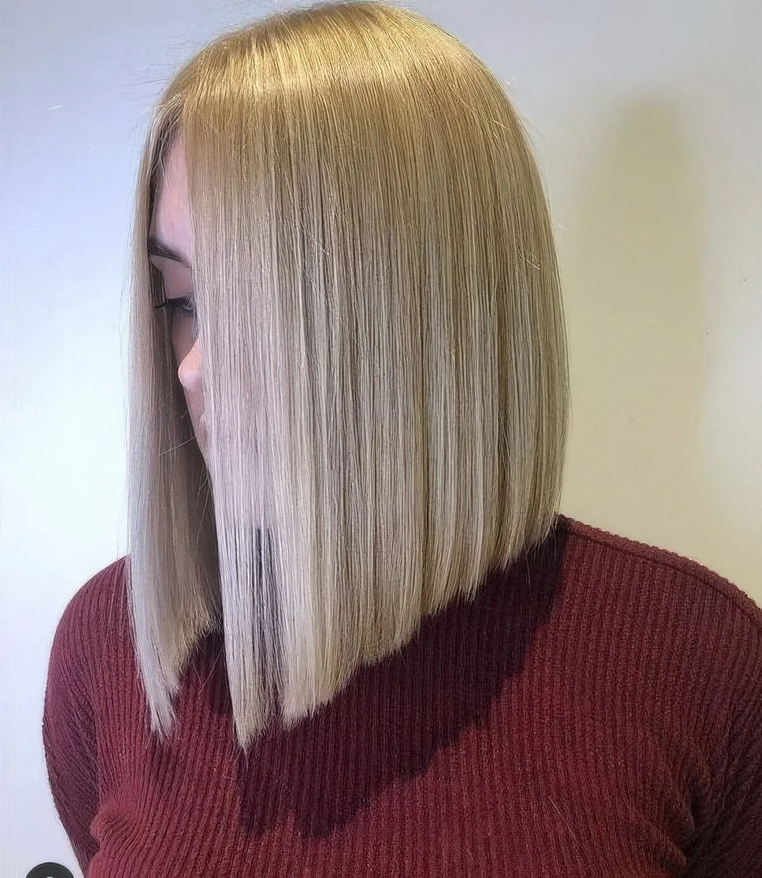 Chic creamy blonde A line long bob with side part.