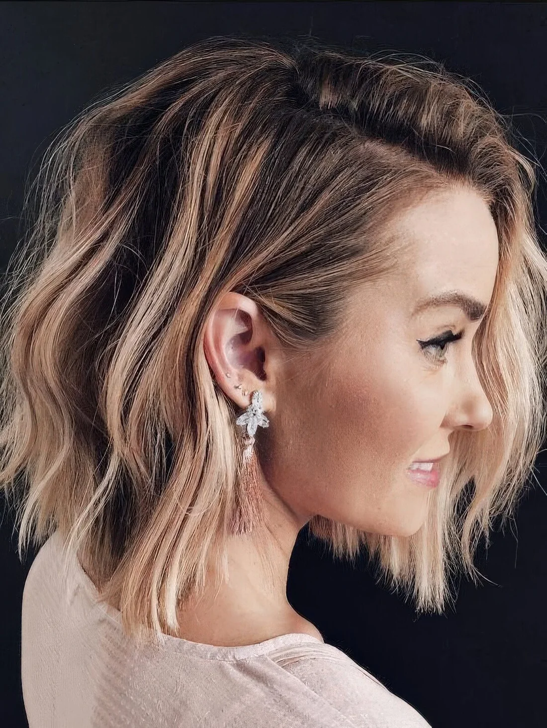 Chic light brunette long bob with blonde highlights and messy waves.
