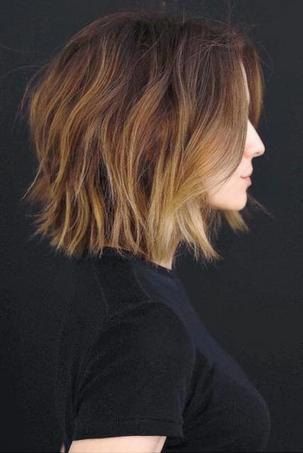 Brunette long bob with caramel and blonde highlights and messy waves.