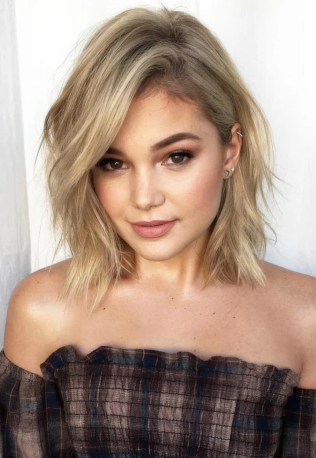 Blonde layered collarbone bob with a messy part and some waves.