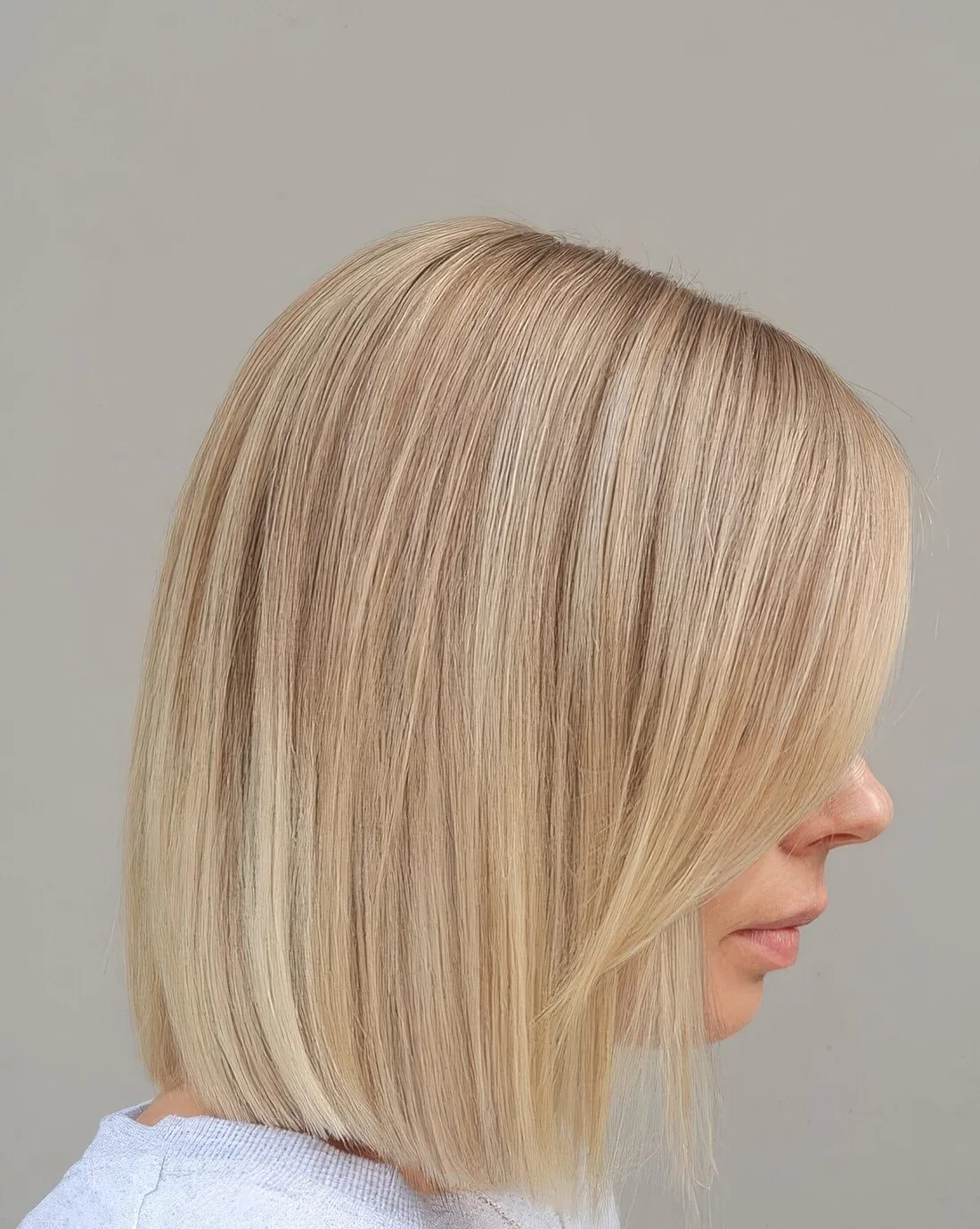 Photo showing blunt blonde bob with side bangs, with the hairstyle clearly visible.