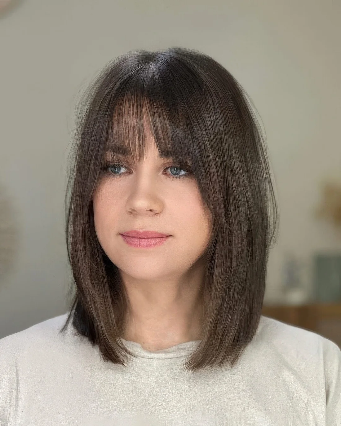 Brunette long bob with wispy bangs.