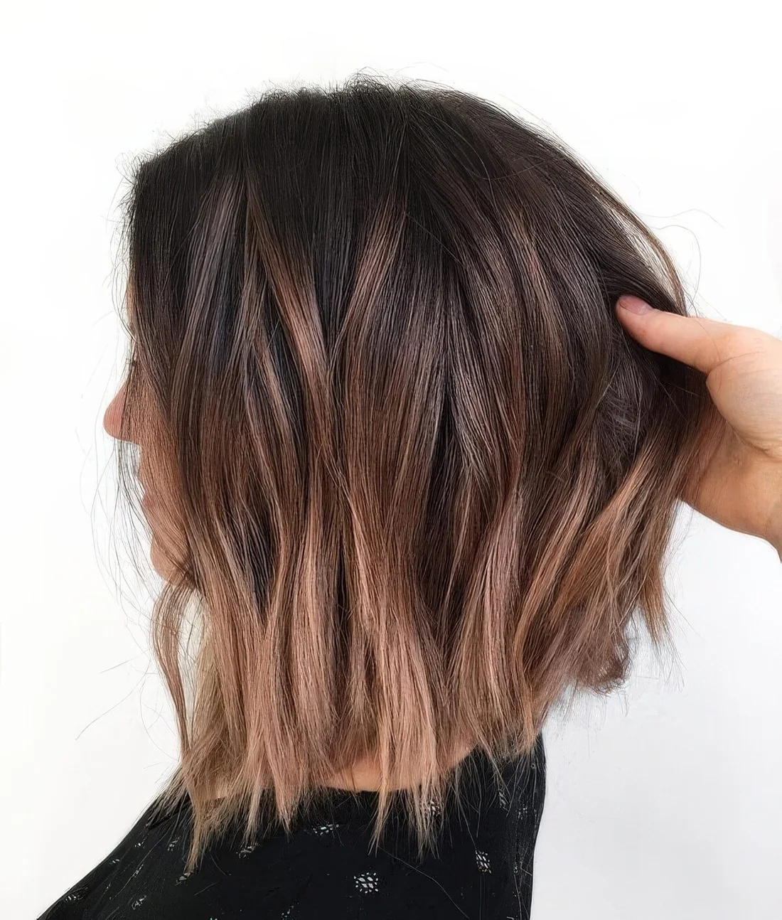 Dark brunette long bob with caramel and mahogany highlights and messy waves.