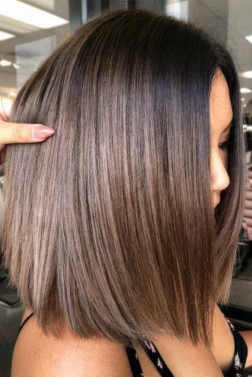 Dark brunette long bob with chestnut highlights and dark root.