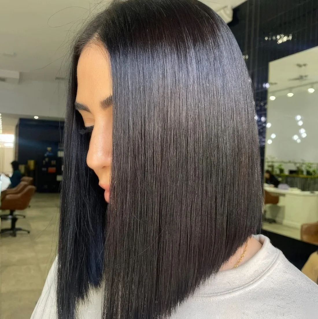 Dramatically sloped almost black glossy angled long bob.