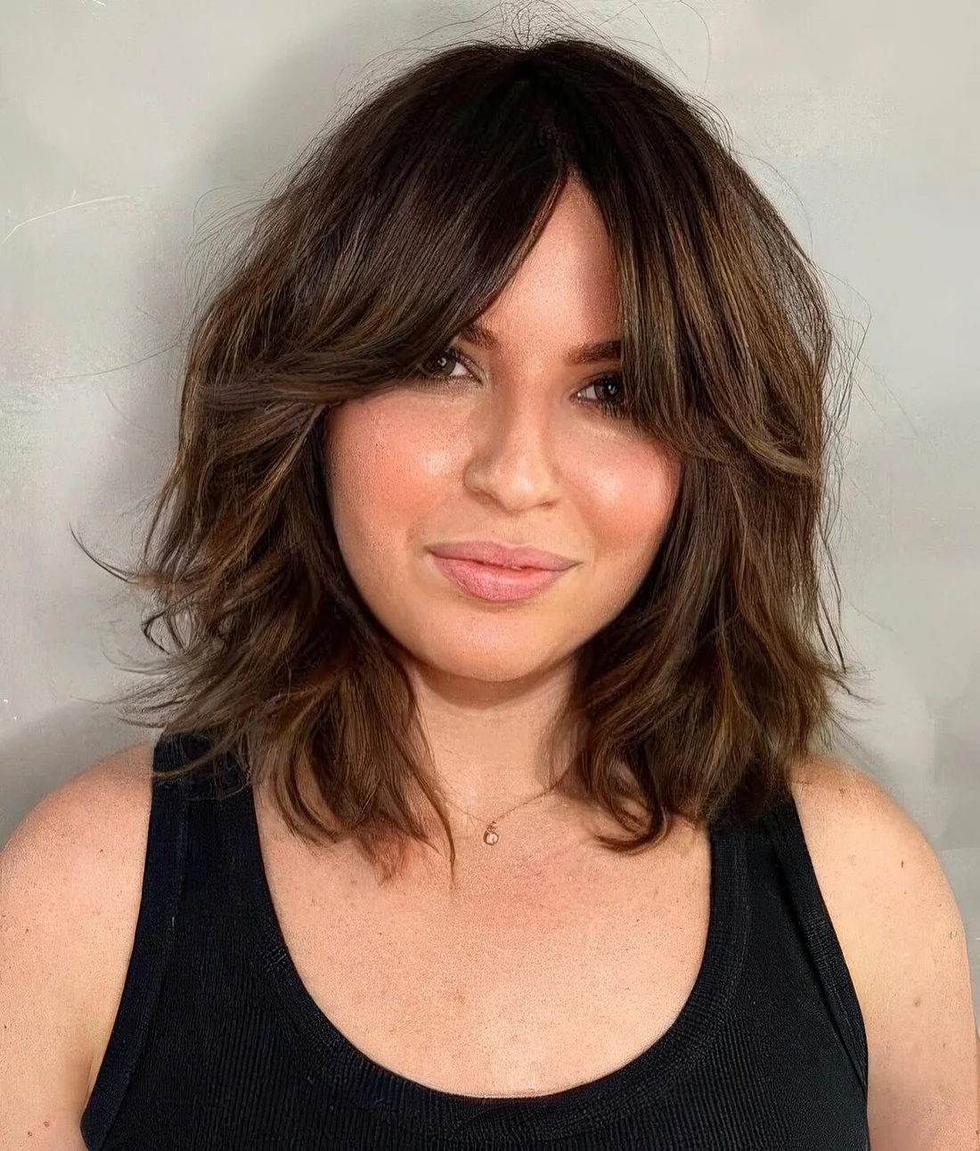 Dark brunette long bob with waves and bottleneck bangs features dimension and.