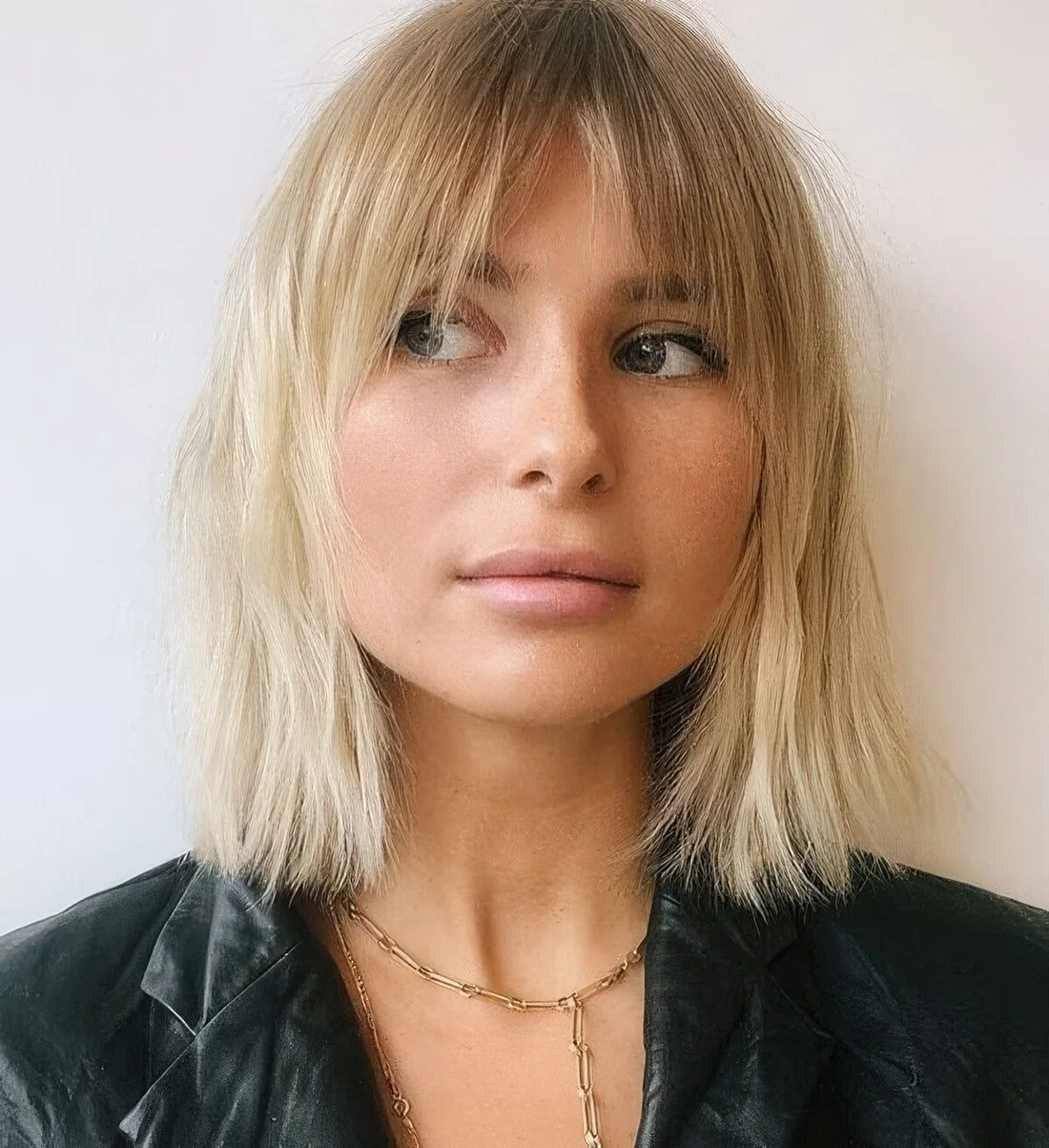 Blonde long bob with bottleneck bangs.