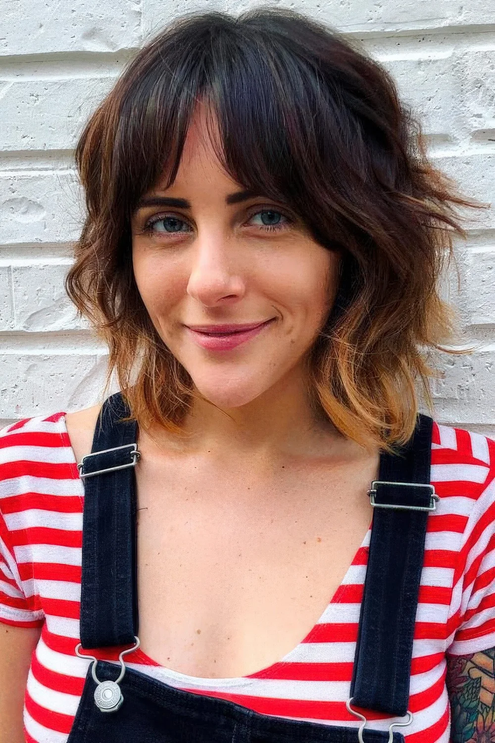 Dark brunette long bob with bottleneck bangs and caramel ombre plus shaggy waves.