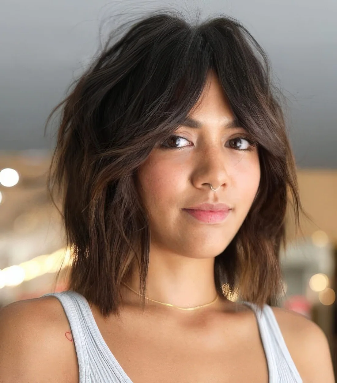 Shaggy dark brunette long bob with acramel ombre and bottleneck bangs plus a messy volume.