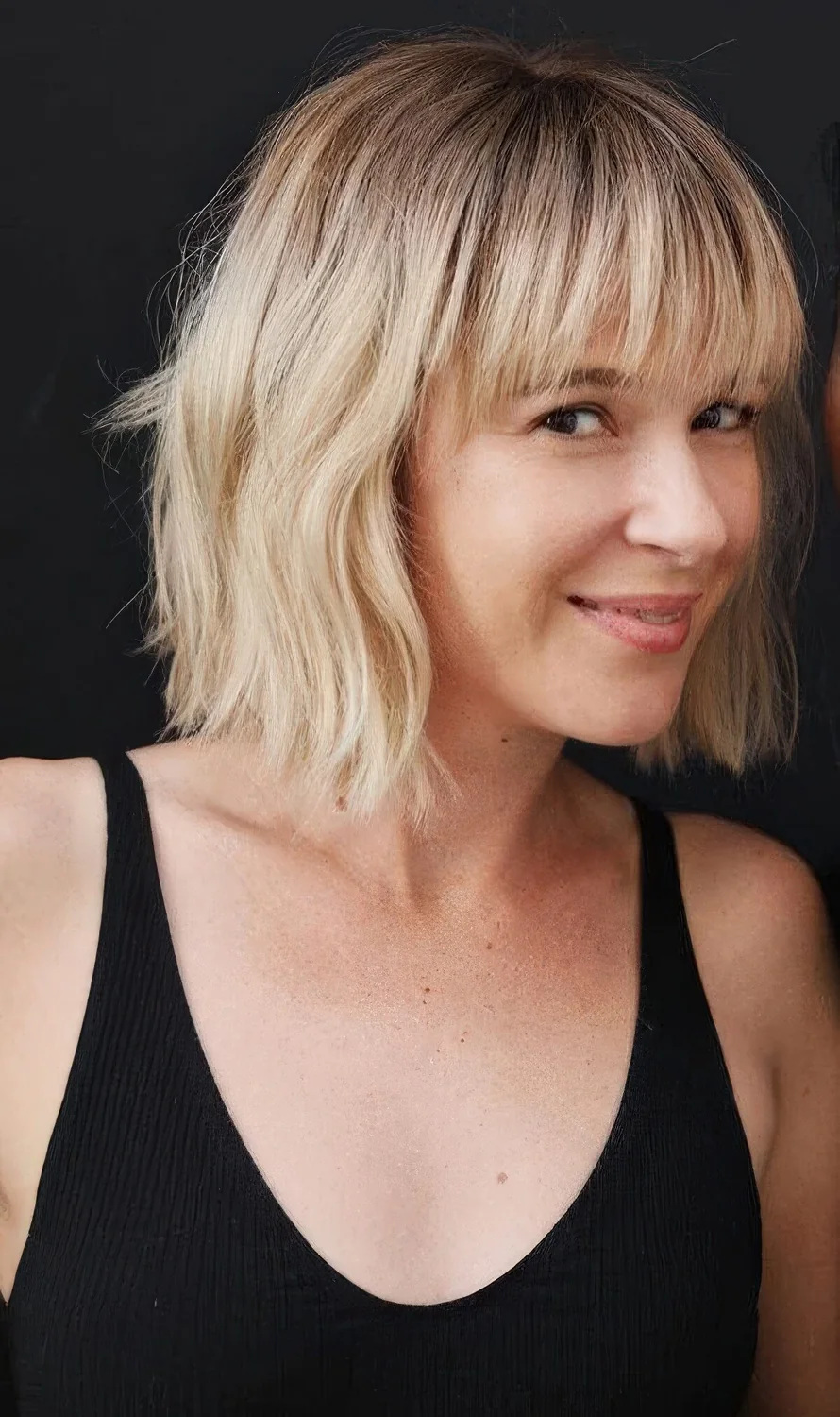 Photo showing blonde wavy bob, with the hairstyle clearly visible.