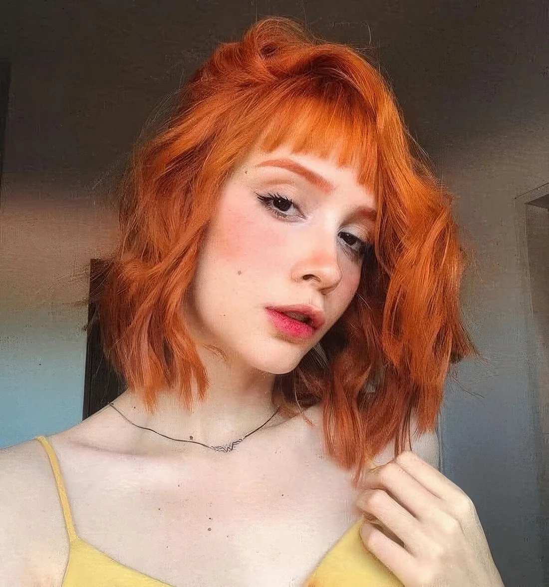 Photo showing orange wavy bob, with the hairstyle clearly visible.