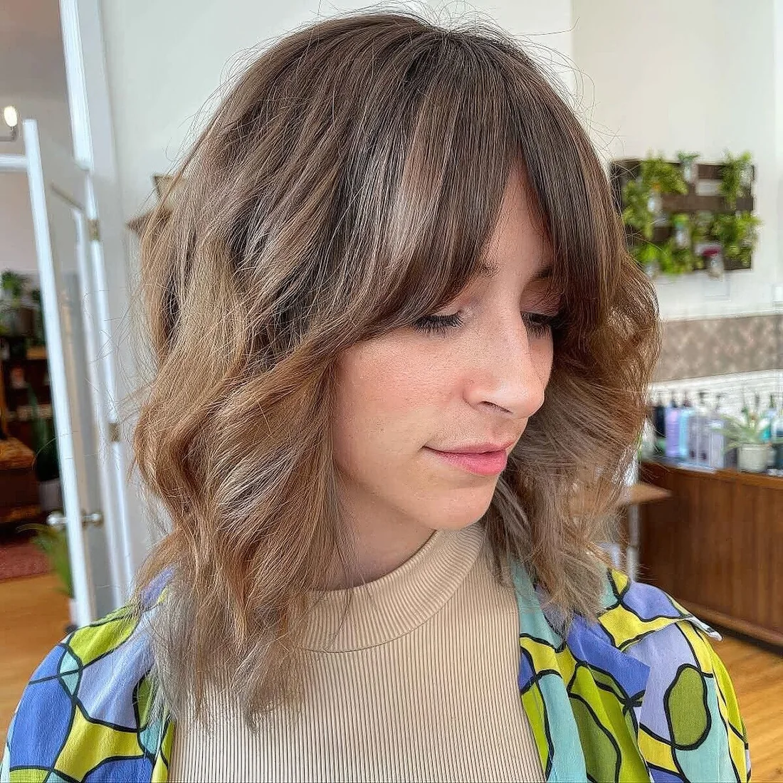 Light brown long wavy bob with curtain fringe and highlights.