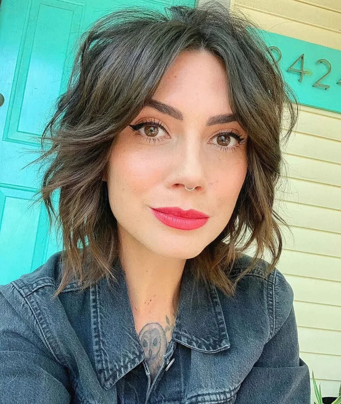 Shaggy dark brown bob with texture and shaggy waves plus curtain bangs.