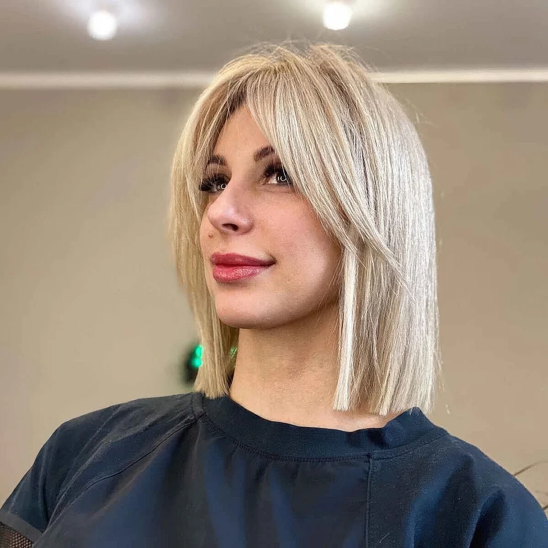 Blonde lob with curtain bangs and straight hair.