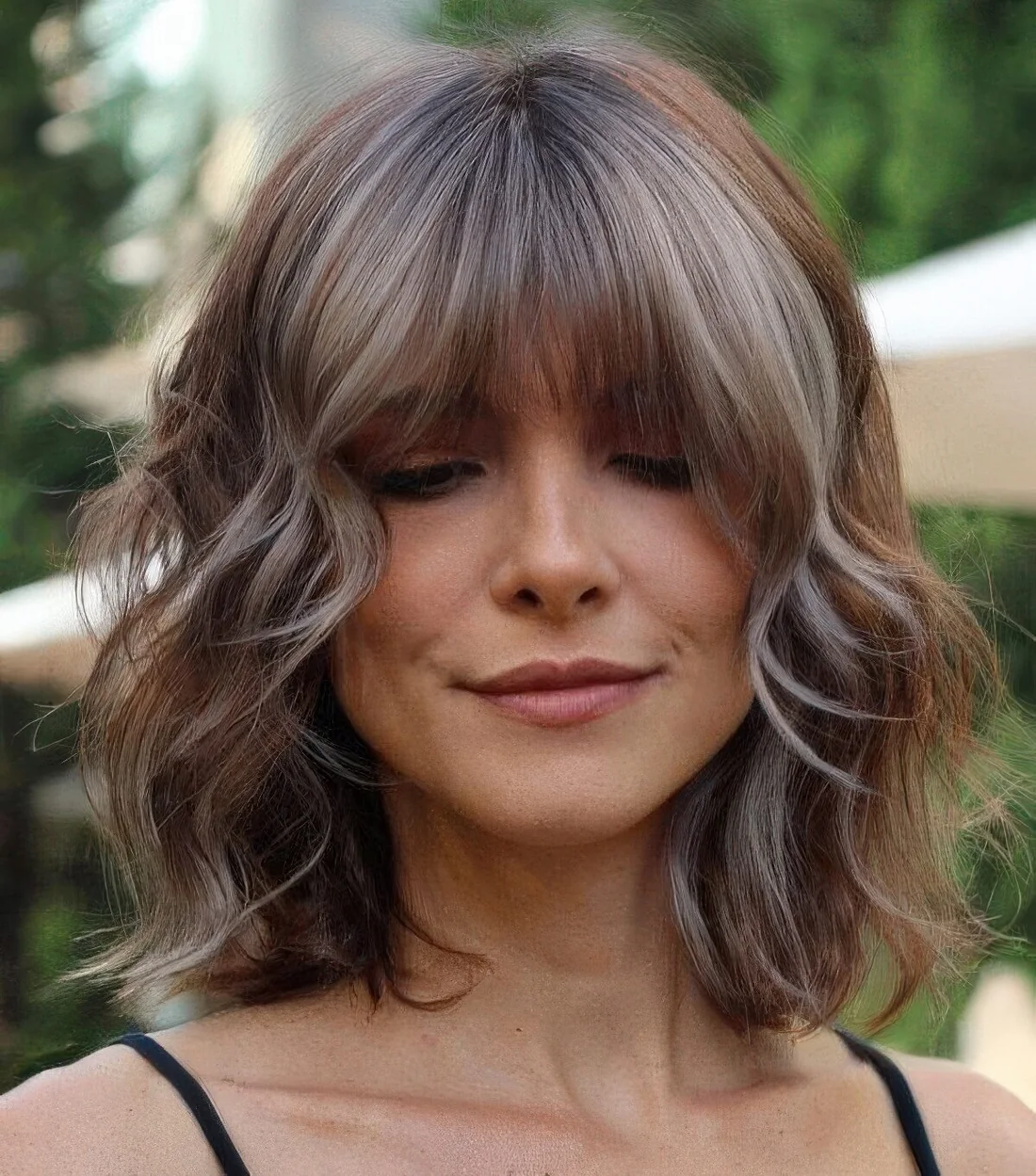 Choppy layered long bob with icy blonde highlights and wispy bangs.