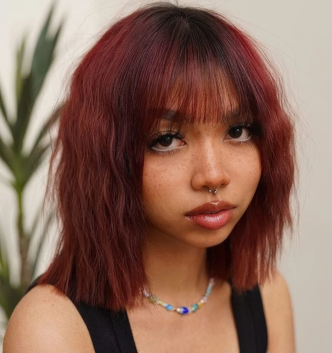Deep auburn wavy bob with wispy bangs.