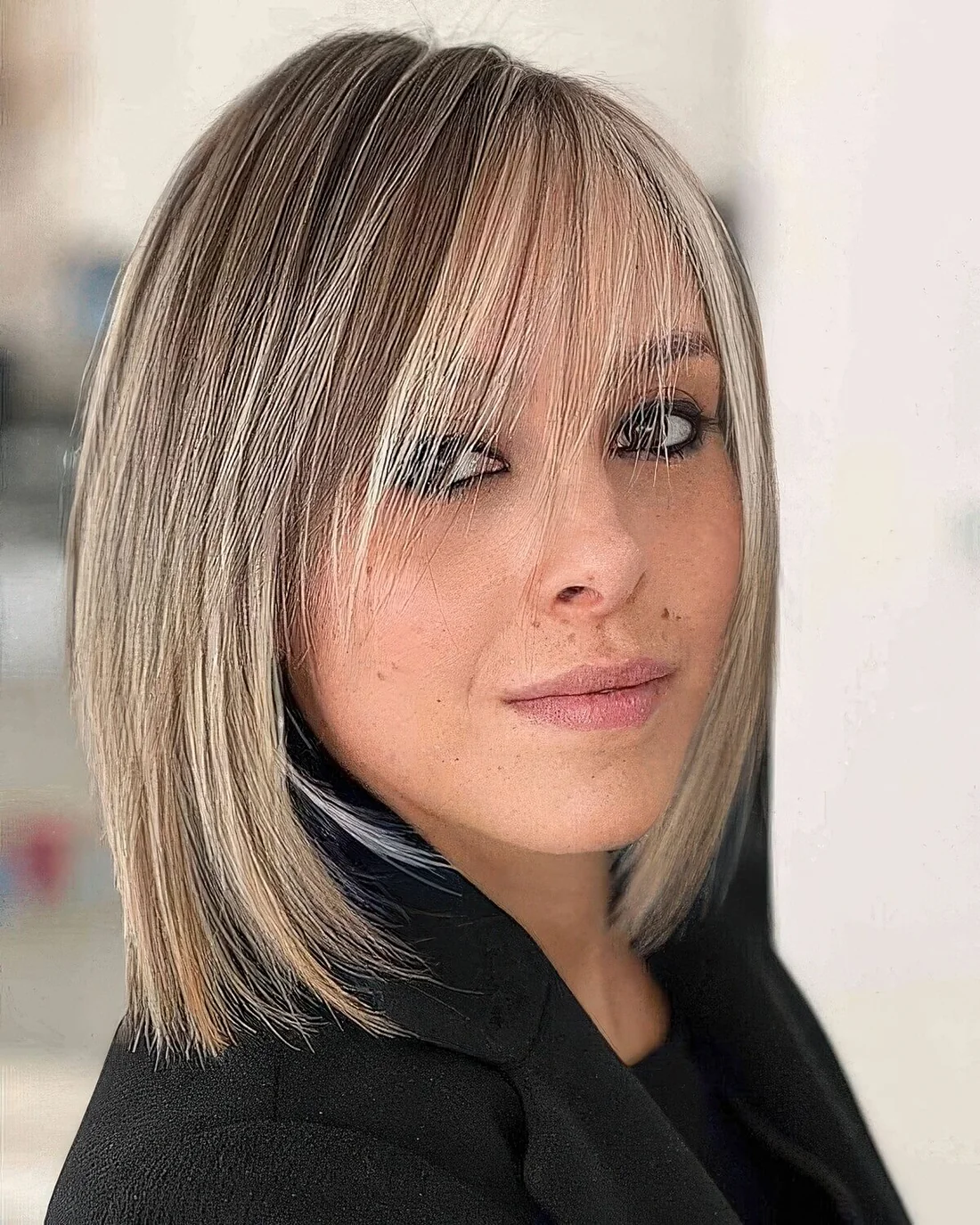 Long blonde bob with highlights and wispy bangs bring elegance and chic and.