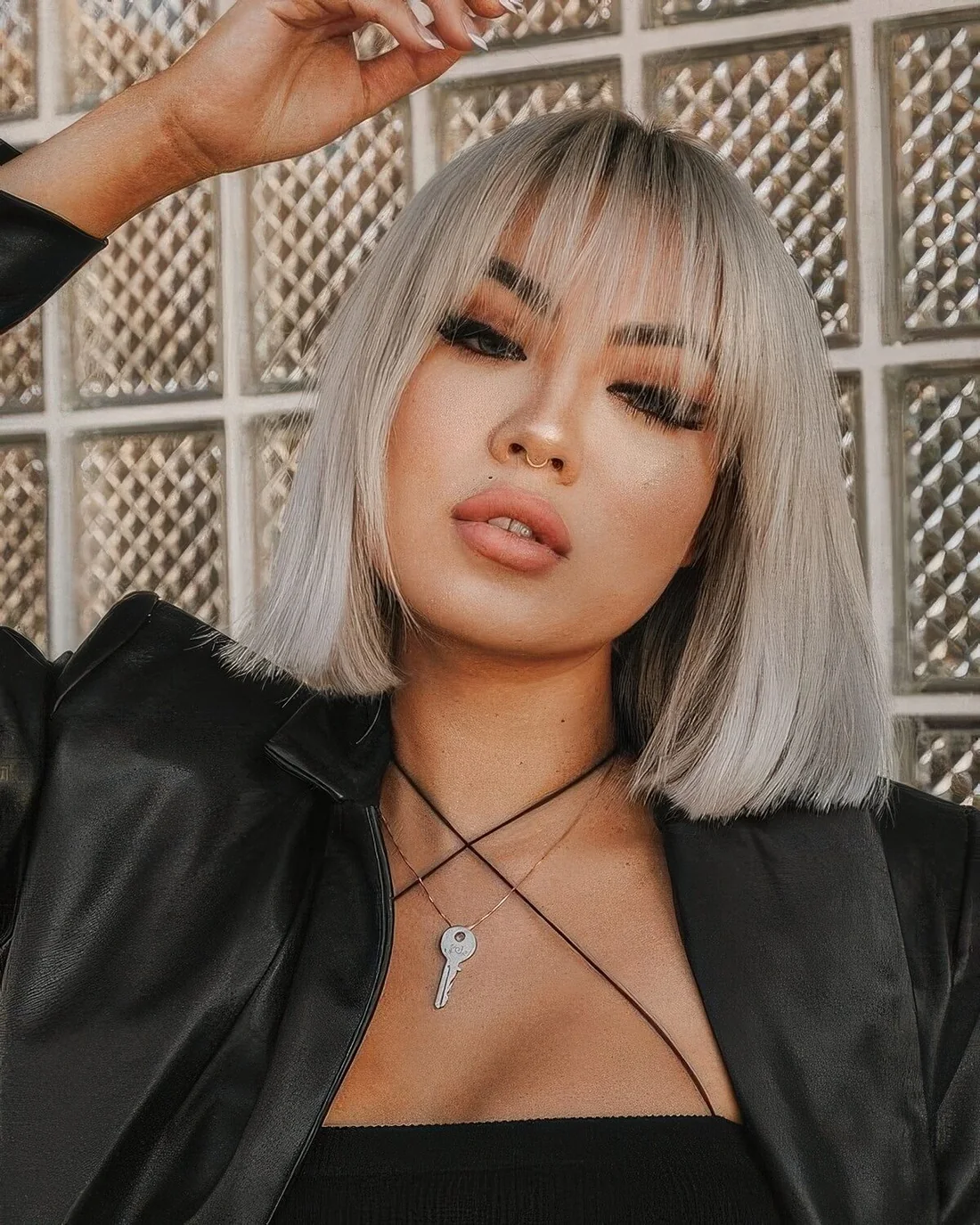 Platinum blonde straight long bob with wispy bangs.