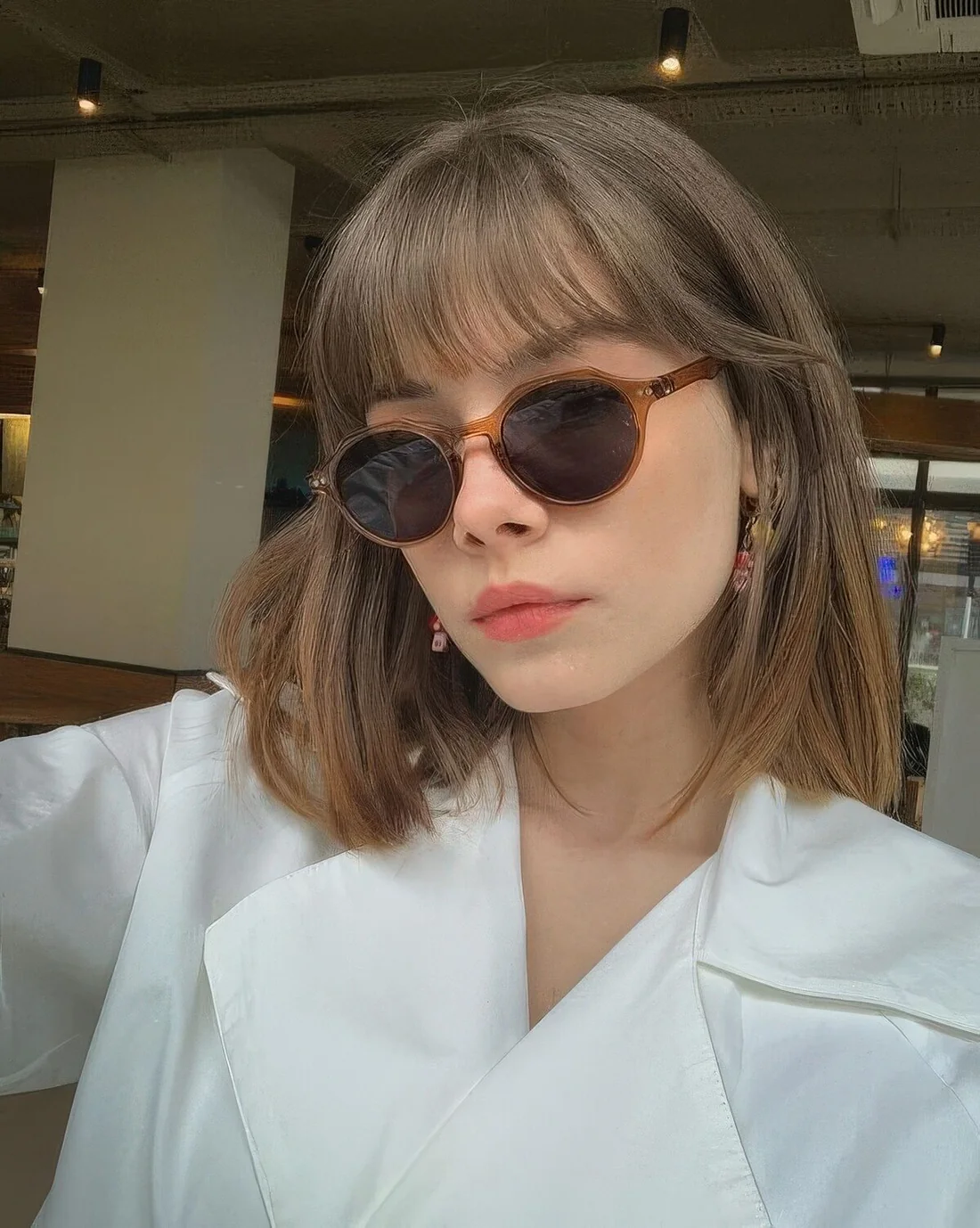 Medium-length brunette hair with wispy bangs to accent the eyes and take off excessive weight off the face.