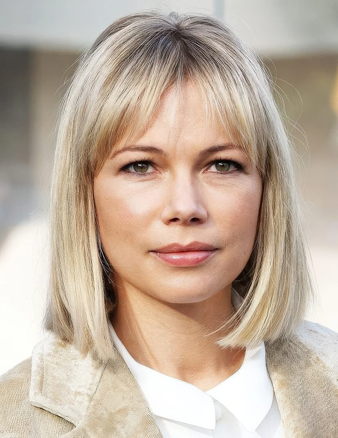 Michelle Williams rocking a long blonde bob with wispy bangs.