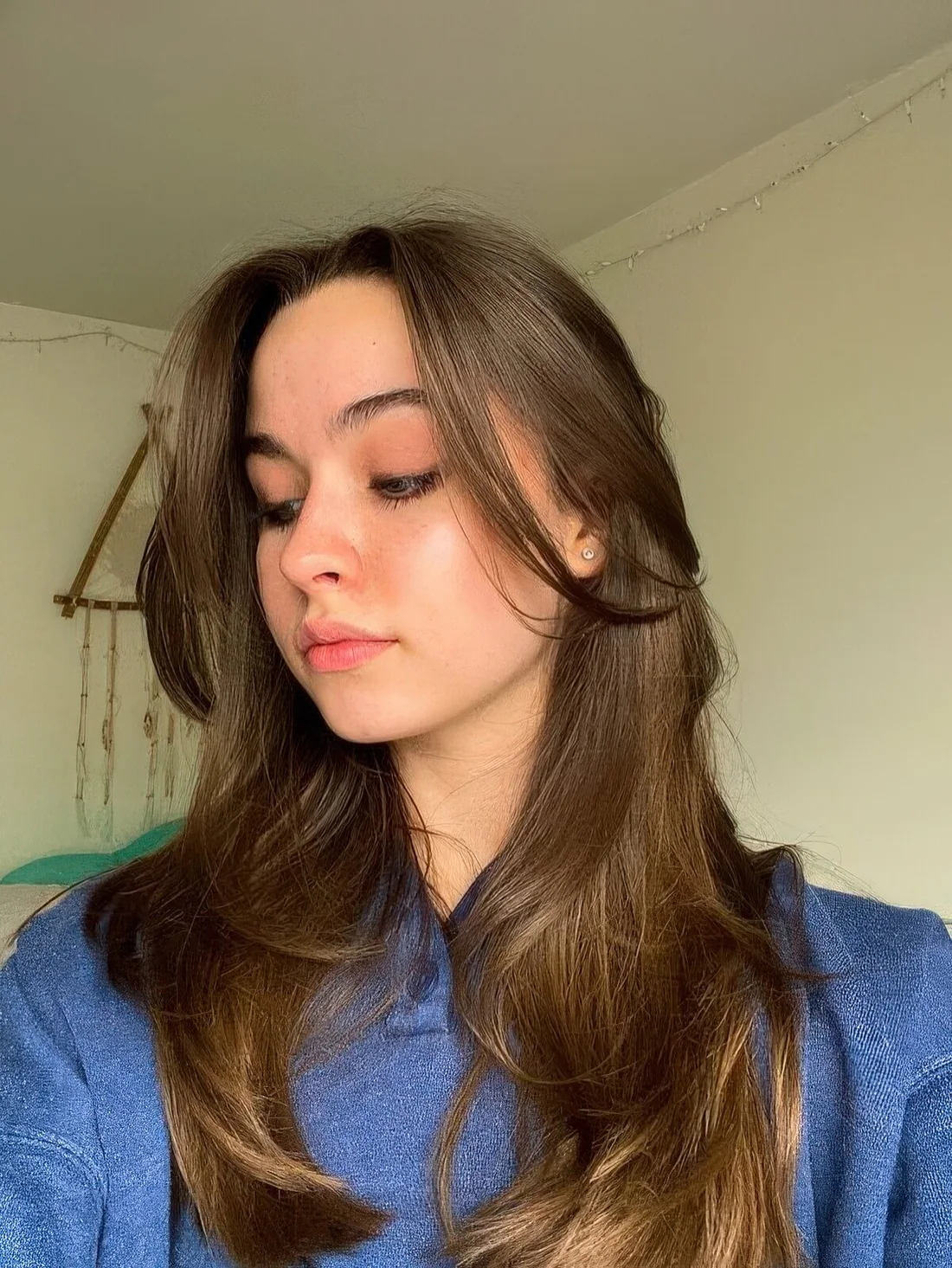 Long layered haircut with long curtain bangs shows off beautiful brunette shades and shine and.