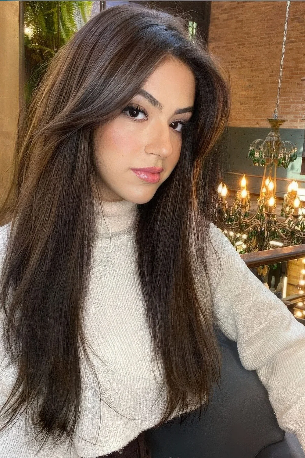 Long dark hair with long curtain bangs to add even more volume to the hairstyle and highlight the face.