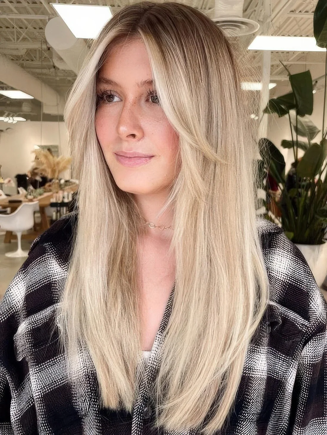 Long blonde hair with long curtain bangs.